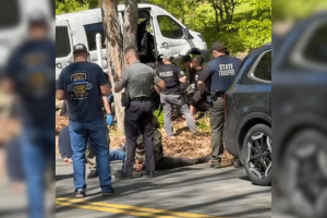 Connecticut State Police and officers detain suspects during a raid on an alleged cockfighting and illegal gambling operation in Tolland on Friday.