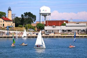 A picture of sailboats in the water in front of the Kenosha, Wisconsin water tower.