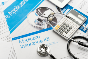 Medicare insurance enrollment documents with stethoscope and calculator, illustrating healthcare fraud investigations, Medicare reimbursement claims, medical billing and tax evasion cases. Burbank laboratory owner jailed after Medicare fraud funded gambling habit