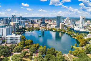 Aerial view of downtown Orlando, Florida skyline surrounding Lake Eola under a bright blue sky with modern skyscrapers and waterfront parks. Florida appeals court upholds permit revocation amid Seminole gaming overhaul