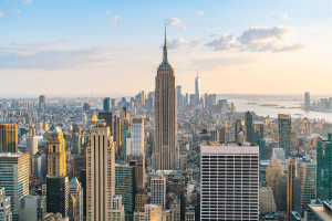 Panoramic view of the New York City skyline featuring the Empire State Building and Lower Manhattan skyscrapers during sunset, highlighting New York's financial and entertainment hub. New York advances bill requiring monthly sports betting account statements