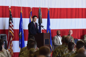 Steil introduces bill restricting congressional prediction market trades. Rep. Bryan Steil speaks at a military event before service members and officials, standing at a podium in front of a large American flag while discussing congressional policy and government ethics reforms.