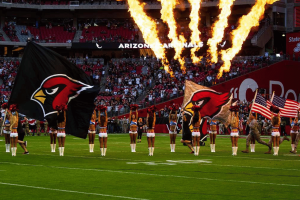 Arizona Cardinals cheerleaders wave team flags during pregame introductions as pyrotechnics erupt at State Farm Stadium before an NFL game in Glendale, Arizona. Cardinals executive Ryan Gold suspended indefinitely amid NFL gambling appeal dispute