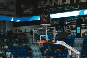 Basketball hoop and shot clock above an indoor arena with spectators in the stands