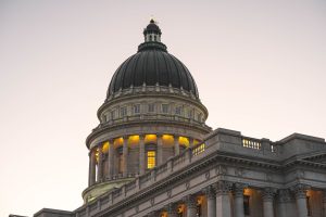 Utah State Capitol dome at dusk with lit windows and Corinthian columns